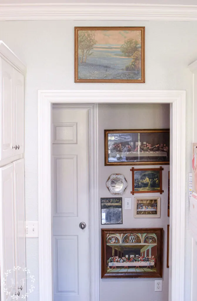 paintings hanging in a kitchen and hallway