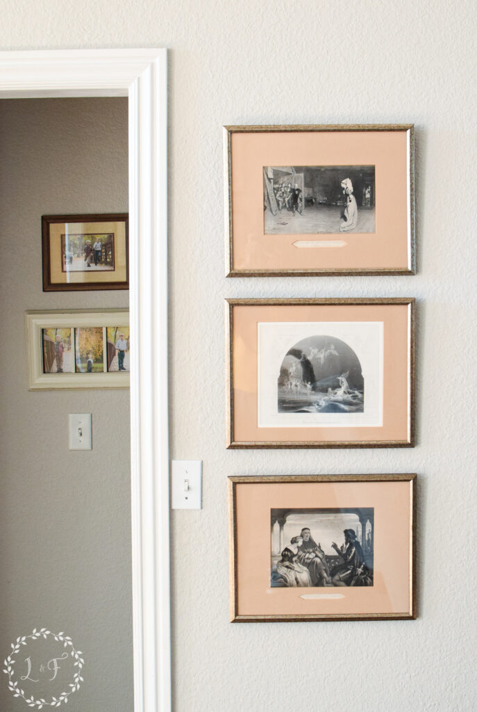 three vintage paintings hanging next to a doorway