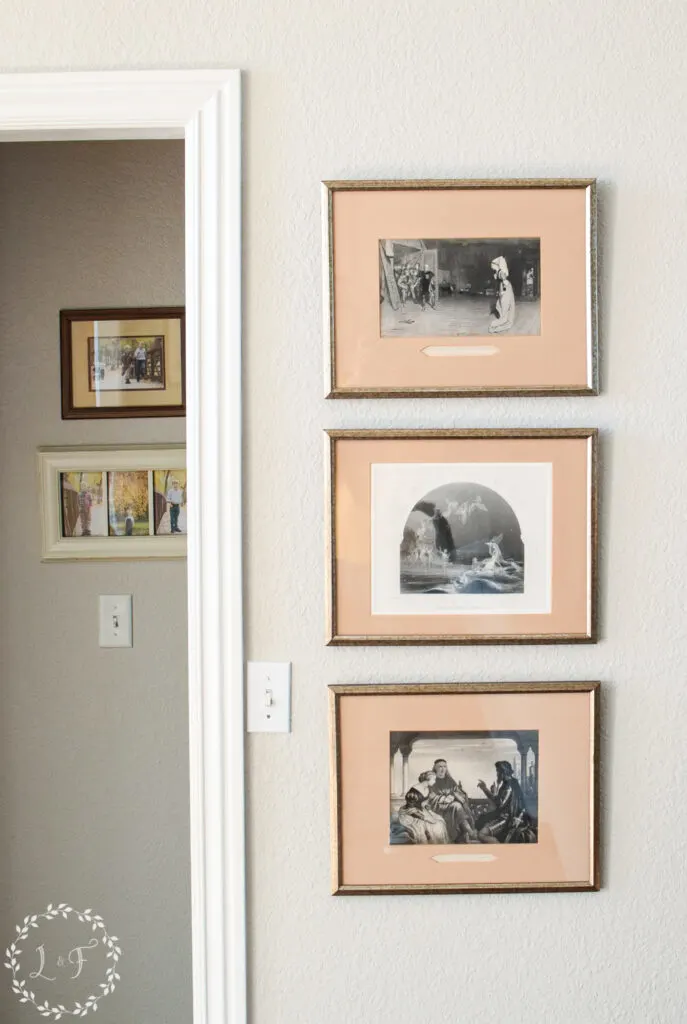 three vintage paintings hanging next to a doorway