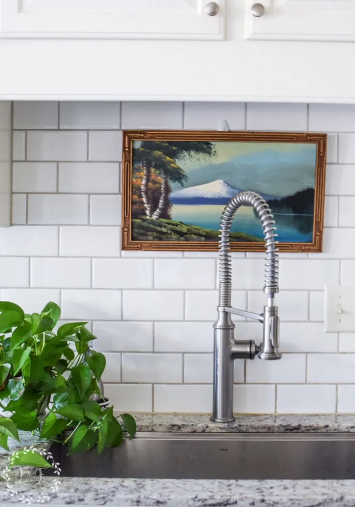 vintage painting hanging over a kitchen sink