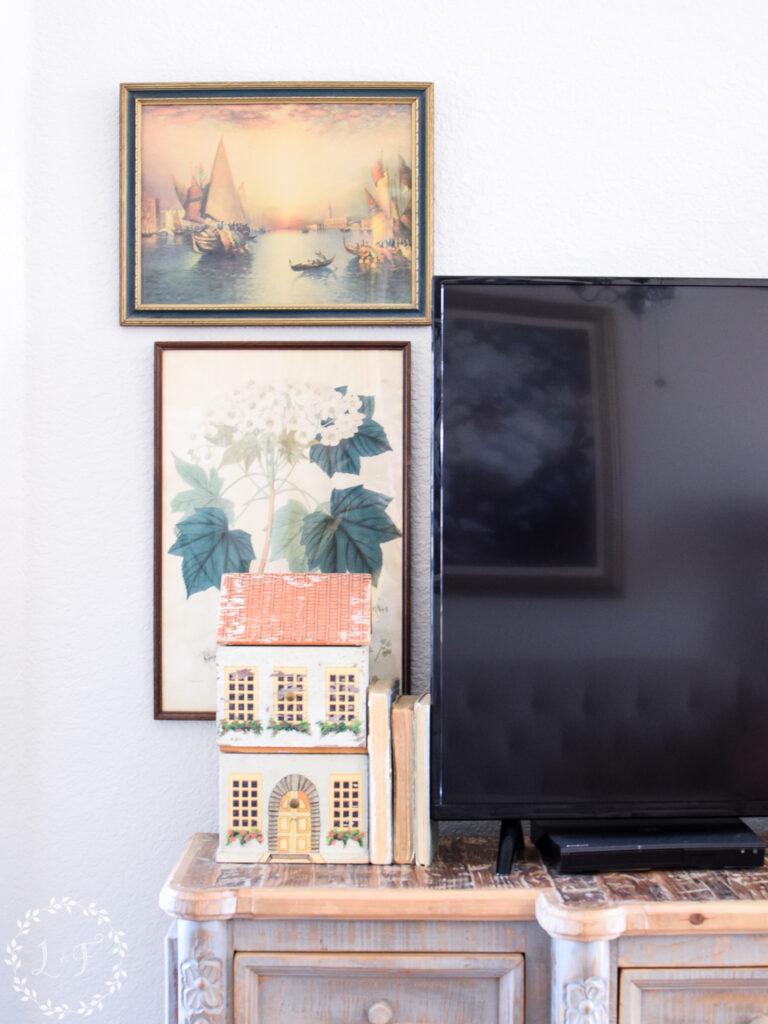 vintage paintings hanging next to a tv